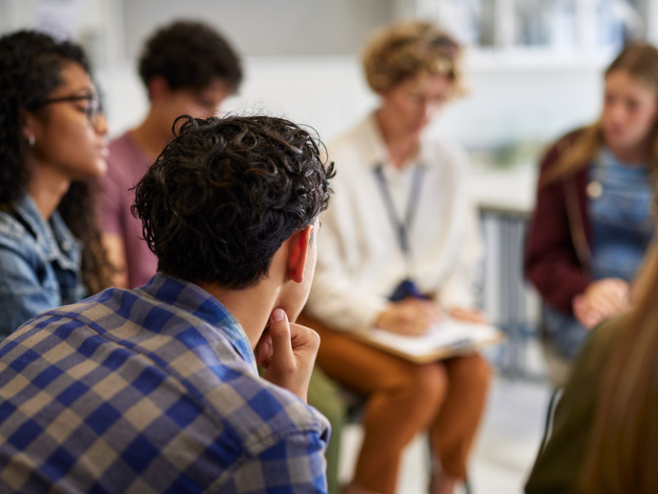 A group of community members and facilitators sitting together in conversation.